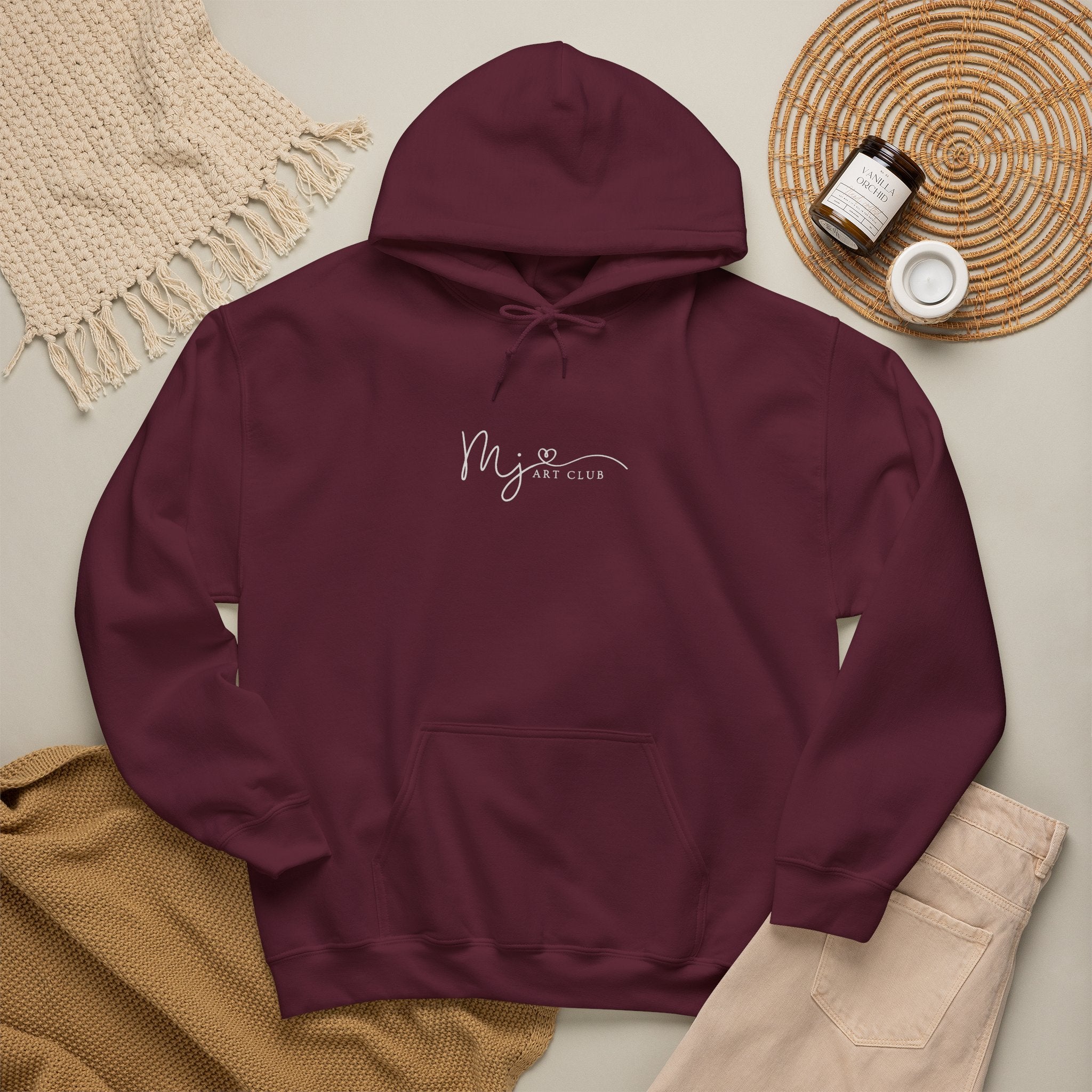 Maroon hoodie with a small graphic on a neutral background
