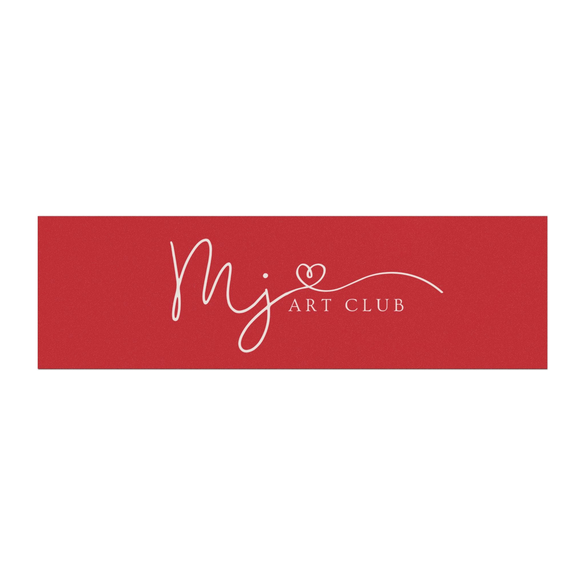 A rectangular red sign or banner with white script reading 'mj' and 'ART CLUB' plus a small heart detail, centered on a light gray background.