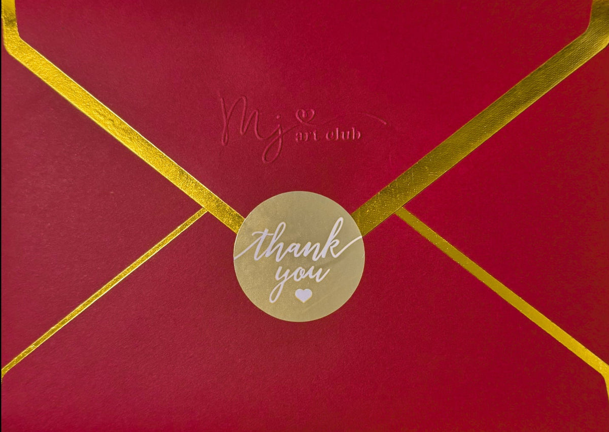 red envelope with gold edges featuring "mj art club" embossed, and a thank you sticker