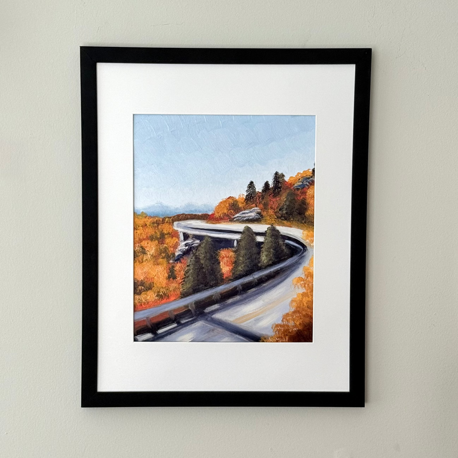 Framed art print of a mountain road featuring fall foliage.