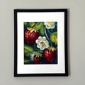 Print of a painting of three strawberries framed against a white wall