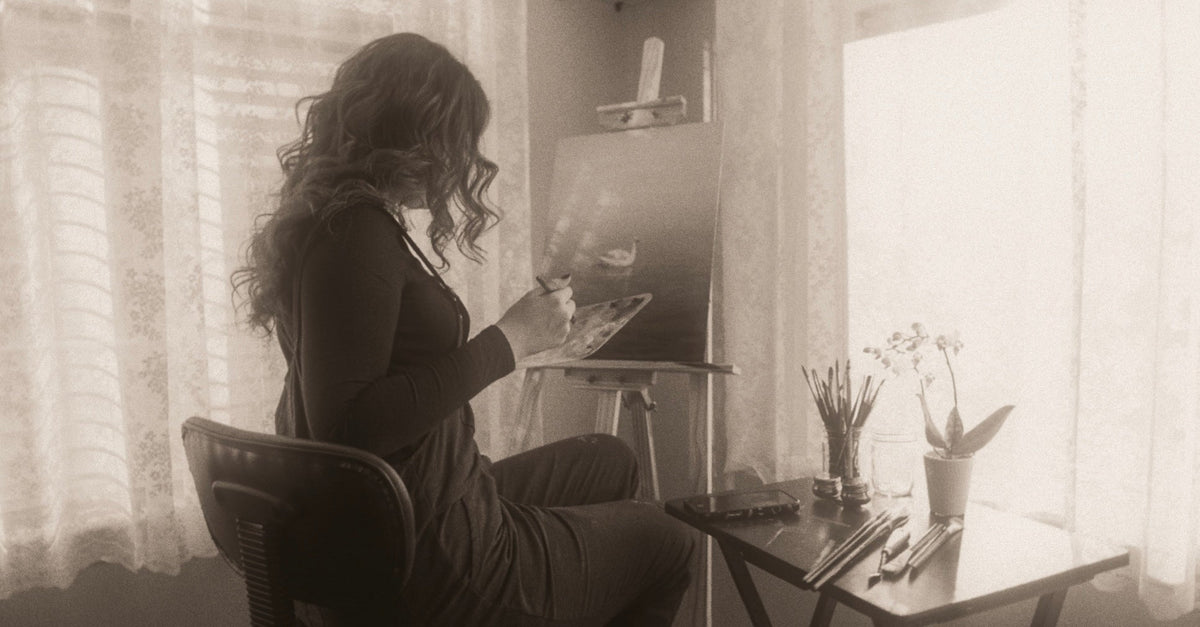 black and white photo of an artist painting a swan