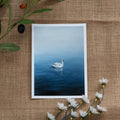 Burlap background with various floral decorations surrounding a fine art print depicting a white swan on a calm blue lake